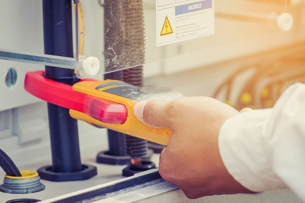 Technician testing solar inverter connections with multimeter